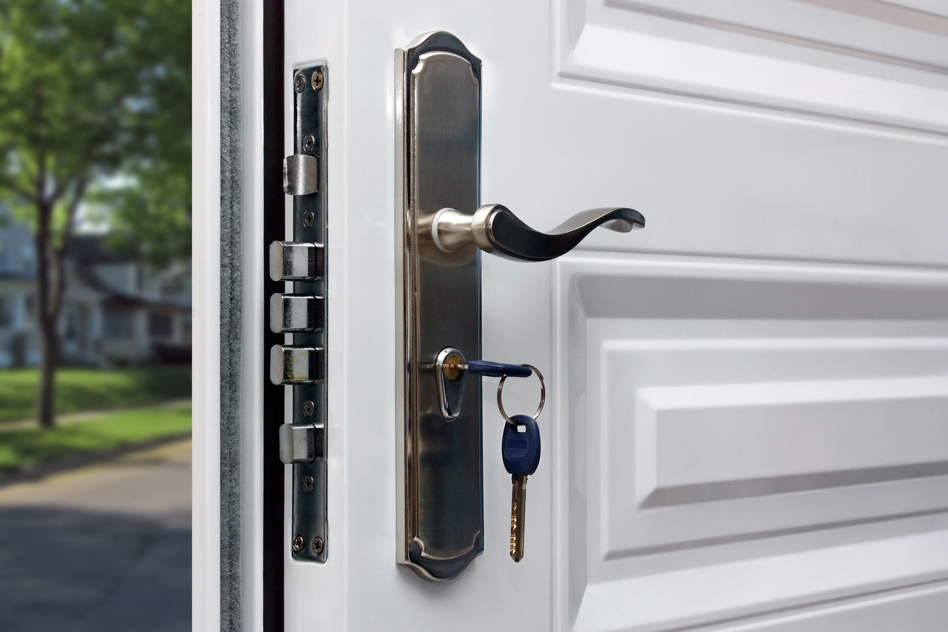 Entrée extérieure résidentielle avec porte d'entrée noire à panneaux verticaux et vitre dépolie carrée