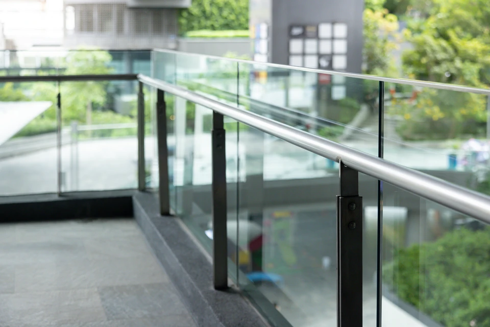 Terrasse extérieure moderne avec deck en lames composites rainurées grises, garde-corps horizontal en aluminium ou acier peint gris