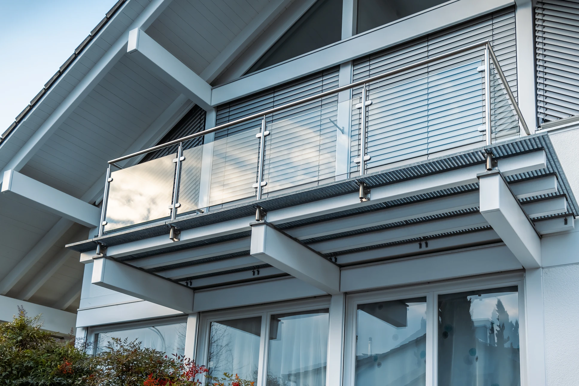 Terrasse surélevée extérieure d'une maison résidentielle avec escalier d'accès et garde-corps blancs